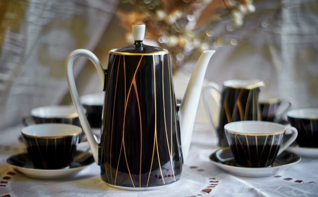 Sophisticated porcelain tea set with black and gold design, perfect for classy gatherings.