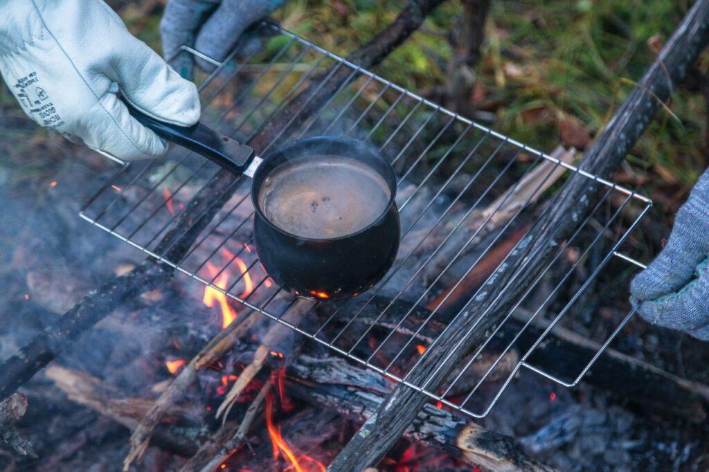Enjoying a hot cup over a campfire, perfect for outdoor adventures and cozy warmth.