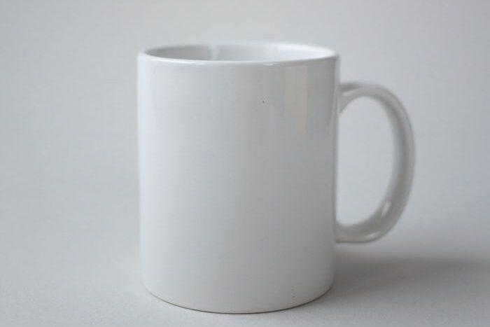 Simple white ceramic mug with a clean, minimalist design against a plain background.